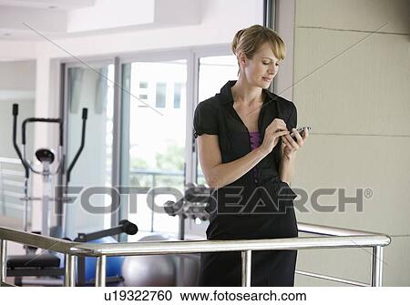 Stock Image - A businesswoman standing in a gym. Fotosearch