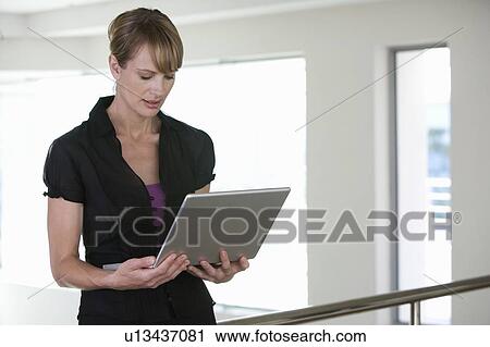 Stock Image - A businesswoman using a laptop. Fotosearch