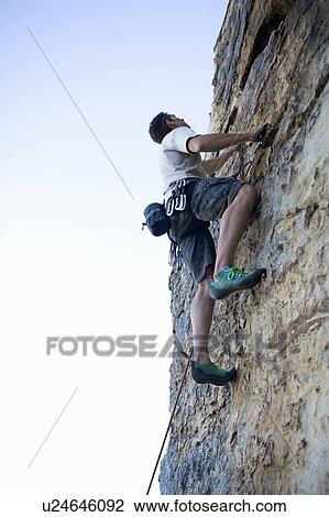 Stock Image - A climber climbing a rock face. Fotosearch