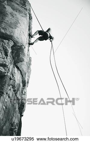 Stock Photography - A climber climbing a rock face. Fotosearch