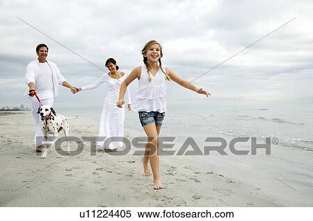 A couple and their daughter walking the dog on the beach View Large Photo Image Stock Photography - A couple and their daughter walking the dog on the beach. Fotosearch