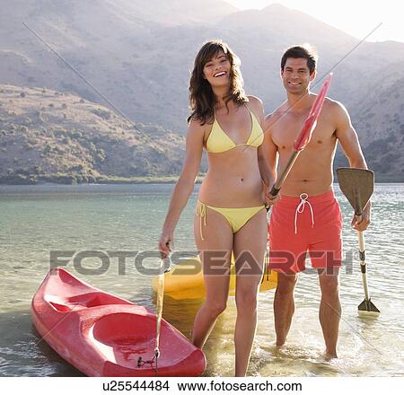 A couple canoeing on a lake View Large Photo Image Picture - A couple canoeing on a lake. Fotosearch