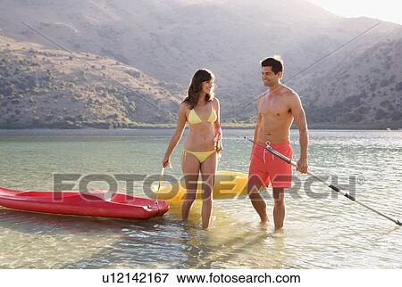 Stock Photo - A couple canoeing on a lake. Fotosearch