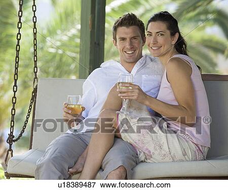 A couple drinking wine on a swing View Large Photo Image Stock Photo - A couple drinking wine on a swing. Fotosearch
