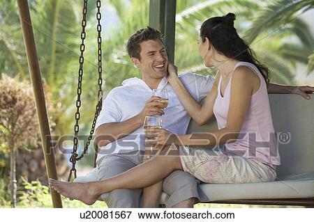 A couple drinking wine on a swing View Large Photo Image Stock Photo - A couple drinking wine on a swing. Fotosearch