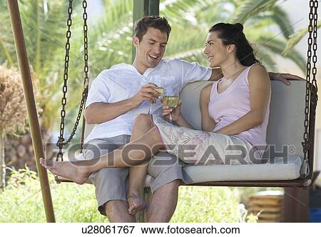 A couple drinking wine on a swing View Large Photo Image Stock Photo - A couple drinking wine on a swing. Fotosearch