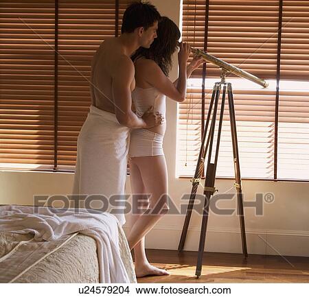 Picture - A couple looking through a telescope. Fotosearch
