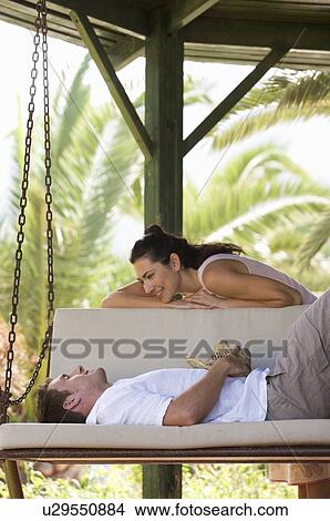 A couple relaxing on a swing View Large Photo Image Picture - A couple relaxing on a swing. Fotosearch