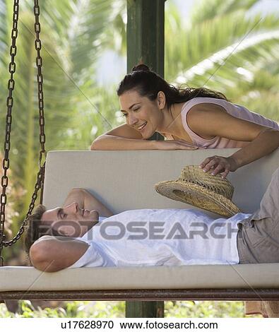 A couple relaxing on a swing View Large Photo Image Stock Image - A couple relaxing on a swing. Fotosearch