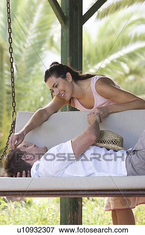 A couple relaxing on a swing View Large Photo Image Stock Photo - A couple relaxing on a swing. Fotosearch