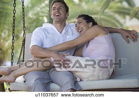 Stock Photo - A couple relaxing on a swing. Fotosearch