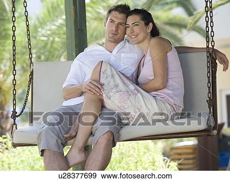 Stock Photo - A couple relaxing on a swing. Fotosearch