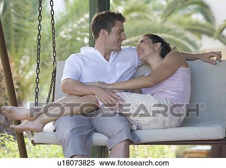 Stock Photography - A couple relaxing on a swing. Fotosearch