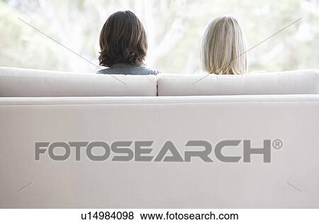 A couple sitting on a sofa View Large Photo Image Stock Photo - A couple sitting on a sofa. Fotosearch