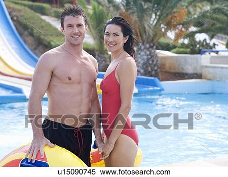 Stock Photography - A couple standing by a pool in a waterpark. Fotosearch