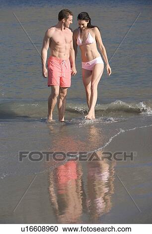 Stock Image - A couple walking along a beach. Fotosearch
