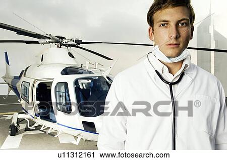 A doctor standing by a helicopter View Large Photo Image Stock Image - A doctor standing by a helicopter. Fotosearch