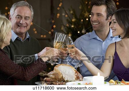 Stock Image - A family celebrating Christmas with a glass of champagne. Fotosearch