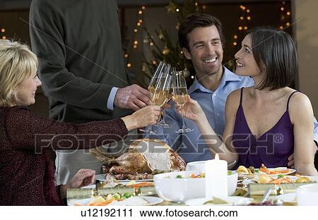 Stock Image - A family celebrating Christmas with a glass of champagne. Fotosearch