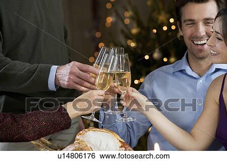 Stock Photograph - A family celebrating Christmas with a glass of champagne. Fotosearch