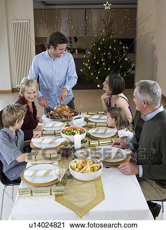 A family sitting down for Christmas dinner View Large Photo Image Stock Image - A family sitting down for Christmas dinner. Fotosearch