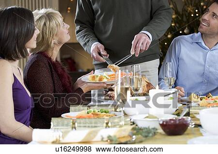 Stock Photo - A family sitting down for Christmas dinner. Fotosearch