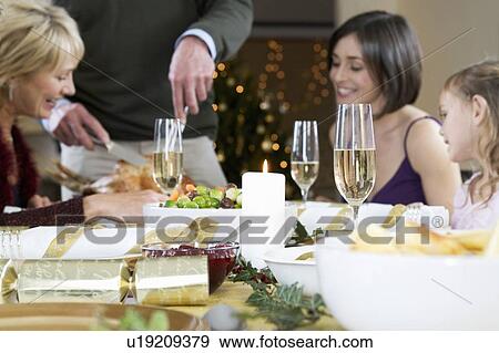 A family sitting down for Christmas dinner View Large Photo Image Stock Photo - A family sitting down for Christmas dinner. Fotosearch