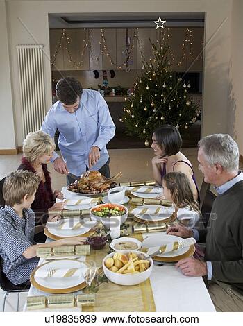 Stock Photo - A family sitting down for Christmas dinner. Fotosearch