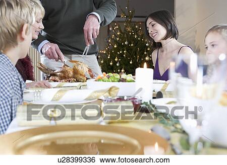 A family sitting down for Christmas dinner View Large Photo Image Stock Photograph - A family sitting down for Christmas dinner. Fotosearch