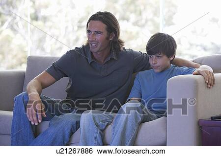 Stock Photograph - A father watching TV with his son. Fotosearch