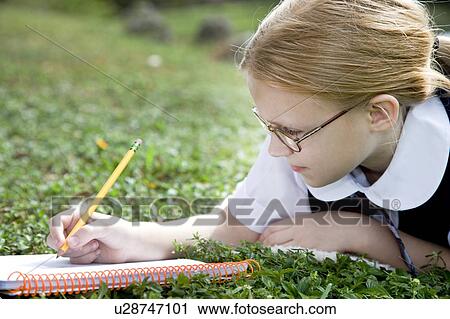 A girl writing in a notebook View Large Photo Image Stock Image - A girl writing in a notebook. Fotosearch