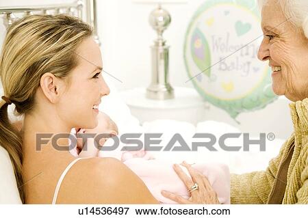 Stock Photo - A grandmother greeting her new grandchild after the birth. Fotosearch