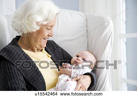 A grandmother holding her new grandchild View Large Photo Image Picture - A grandmother holding her new grandchild. Fotosearch