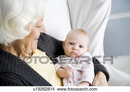 A grandmother holding her new grandchild View Large Photo Image Picture - A grandmother holding her new grandchild. Fotosearch