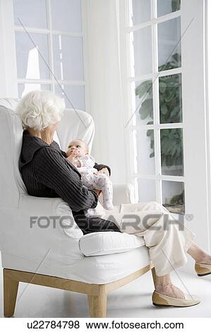 Stock Photo - A grandmother holding her new grandchild. Fotosearch