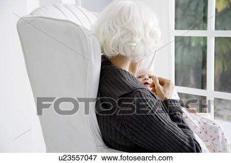 A grandmother holding her new grandchild View Large Photo Image Stock Photo - A grandmother holding her new grandchild. Fotosearch
