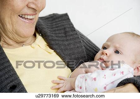 A grandmother holding her new grandchild View Large Photo Image Stock Photo - A grandmother holding her new grandchild. Fotosearch