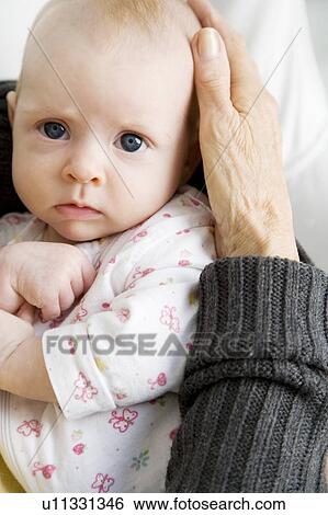 A grandmother holding her new grandchild View Large Photo Image Stock Photograph - A grandmother holding her new grandchild. Fotosearch