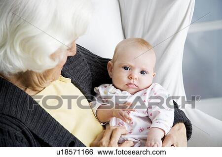 Stock Photograph - A grandmother holding her new grandchild. Fotosearch