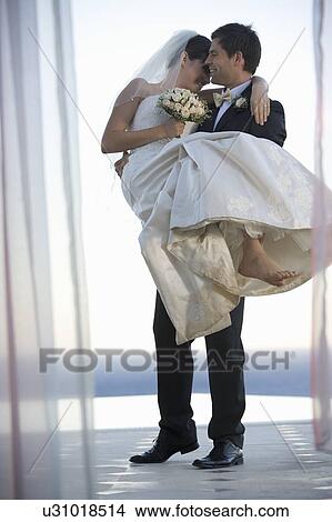 A groom carrying his bride View Large Photo Image Picture - A groom carrying his bride. Fotosearch