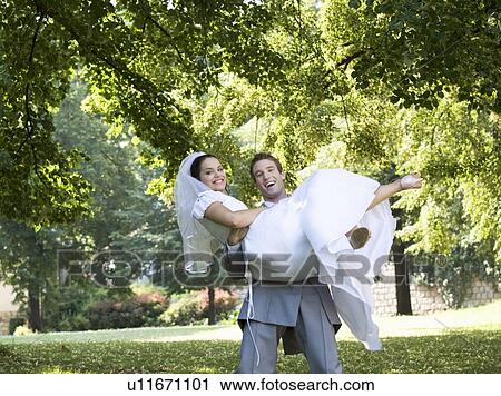 A groom carrying his bride View Large Photo Image Stock Image - A groom carrying his bride. Fotosearch