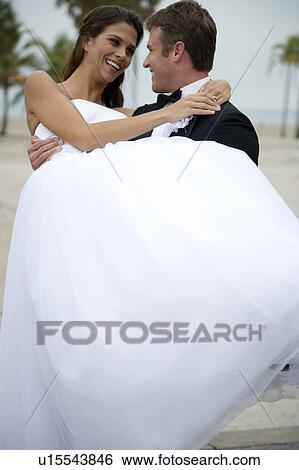A groom carrying his bride View Large Photo Image Stock Photograph - A groom carrying his bride. Fotosearch