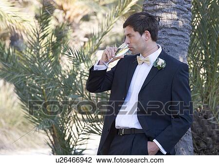 Stock Image - A groom drinking champagne. Fotosearch