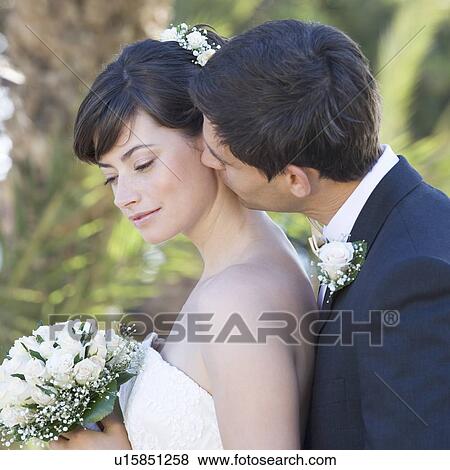 Stock Photo - A groom kissing his bride. Fotosearch