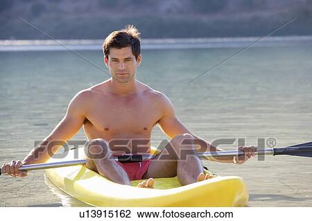 Stock Image - A man canoeing on a lake. Fotosearch