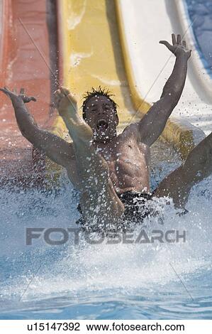 A man coming down a slide in a waterpark View Large Photo Image Stock Image - A man coming down a slide in a waterpark. Fotosearch