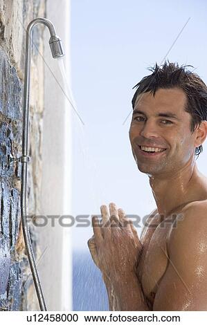 Stock Image - A man cooling off under a shower. Fotosearch