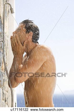 Stock Image - A man cooling off under a shower. Fotosearch