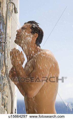 Stock Photo - A man cooling off under a shower. Fotosearch
