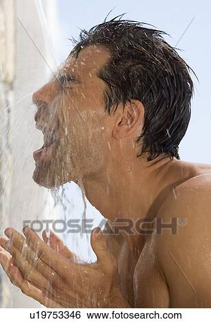Stock Photograph - A man cooling off under a shower. Fotosearch